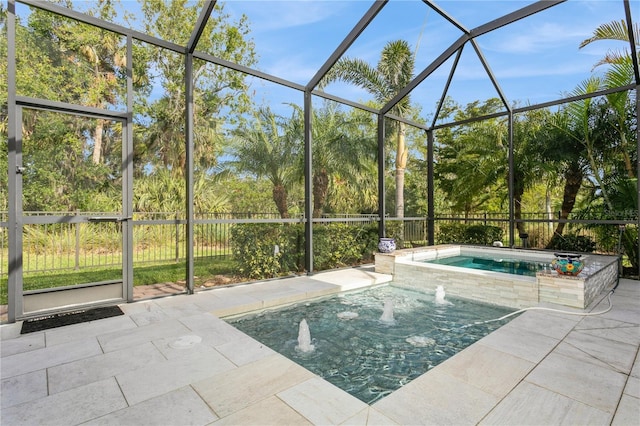 view of swimming pool featuring pool water feature, glass enclosure, a patio area, and a jacuzzi