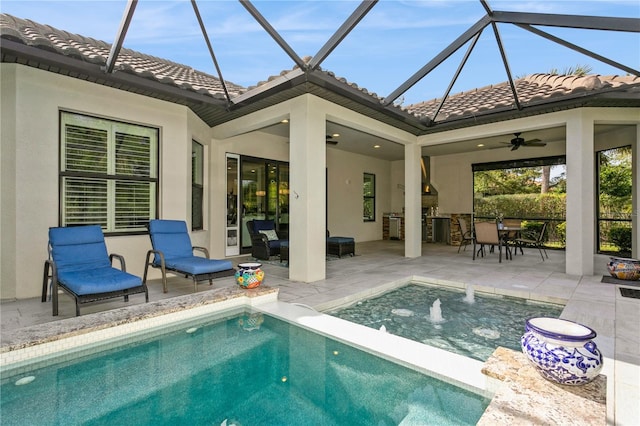 view of swimming pool featuring ceiling fan, exterior kitchen, pool water feature, and a patio