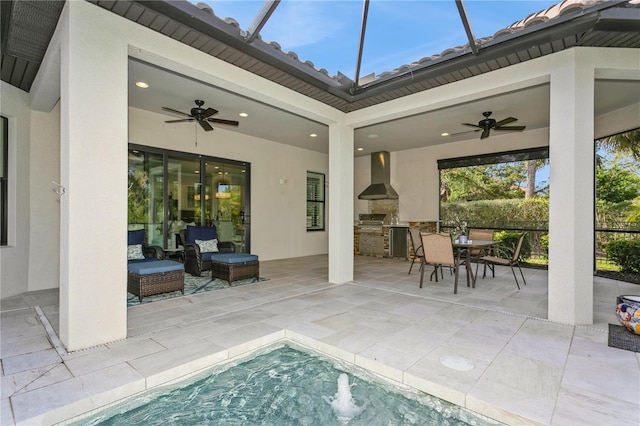 view of patio featuring ceiling fan, a grill, and exterior kitchen