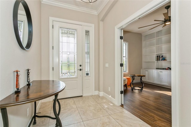 entryway featuring ceiling fan, light tile patterned floors, and crown molding