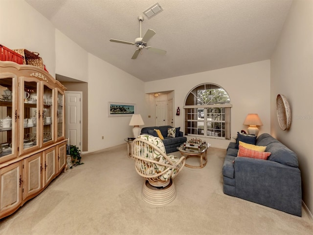 living room with light carpet, ceiling fan, a textured ceiling, and high vaulted ceiling