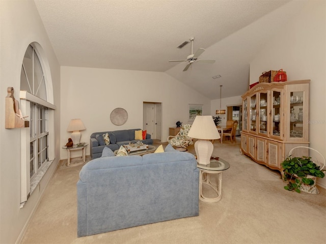 carpeted living room with ceiling fan, a textured ceiling, and vaulted ceiling