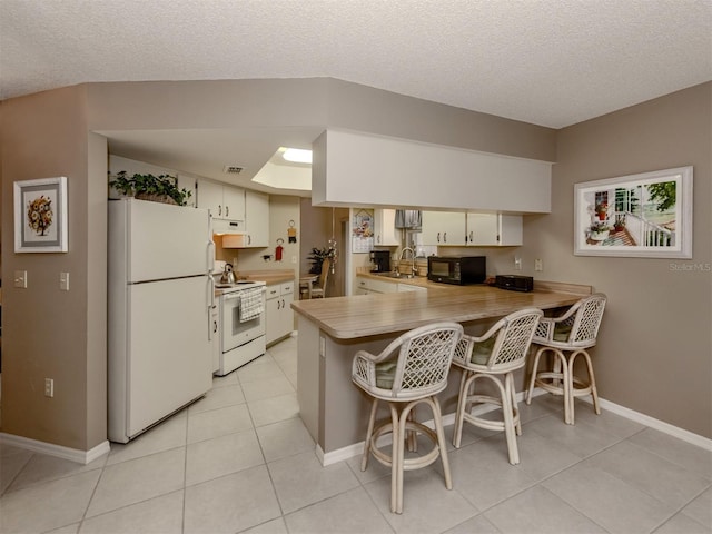 kitchen featuring white appliances, a textured ceiling, sink, kitchen peninsula, and a breakfast bar area