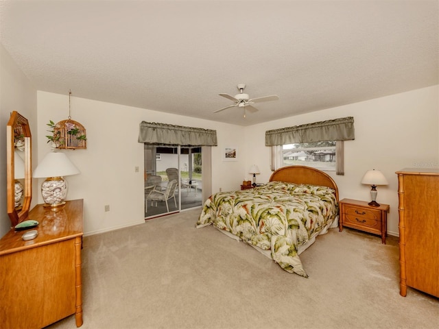 carpeted bedroom with ceiling fan, access to exterior, and a textured ceiling