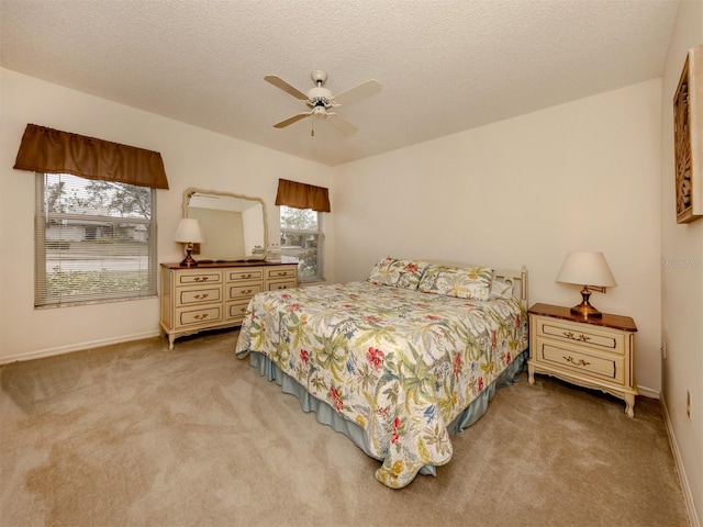 bedroom with ceiling fan, light colored carpet, and multiple windows