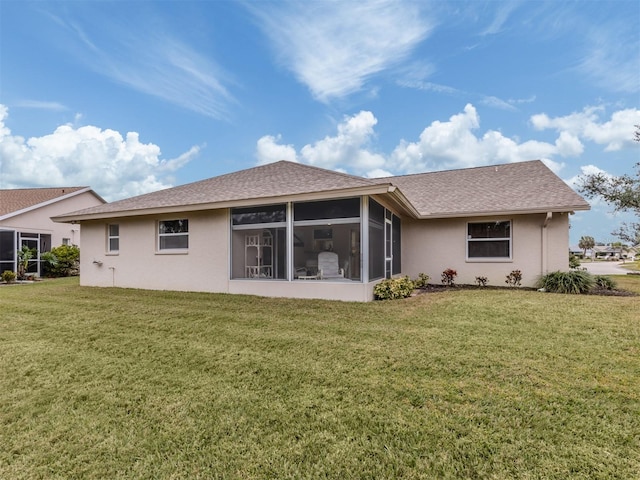 rear view of house with a yard and a sunroom