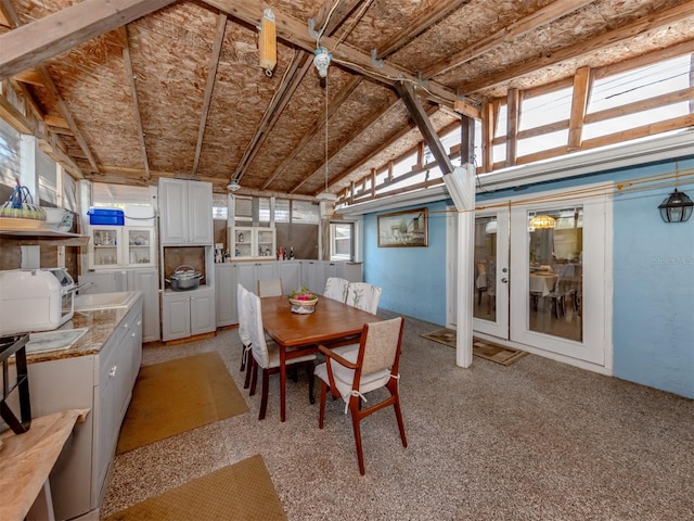 dining area featuring lofted ceiling, french doors, sink, and plenty of natural light