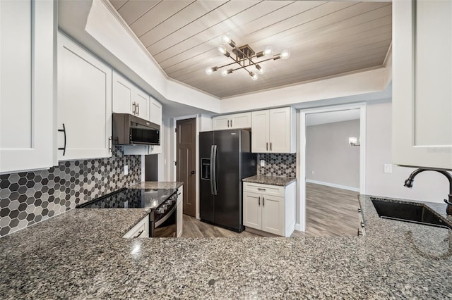 kitchen with wooden ceiling, white cabinets, sink, dark stone countertops, and fridge with ice dispenser