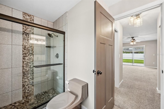 bathroom with ceiling fan, a shower with door, and toilet