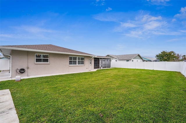 back of property featuring a yard and a sunroom