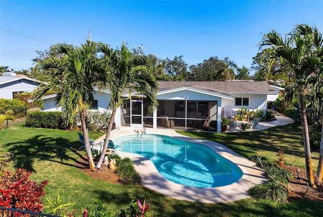 view of swimming pool featuring a lawn, a sunroom, and a patio