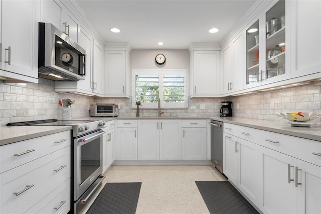 kitchen with backsplash, sink, white cabinets, and appliances with stainless steel finishes