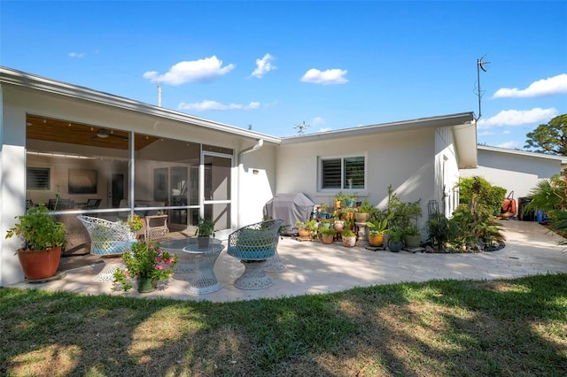 back of house featuring a yard and a sunroom