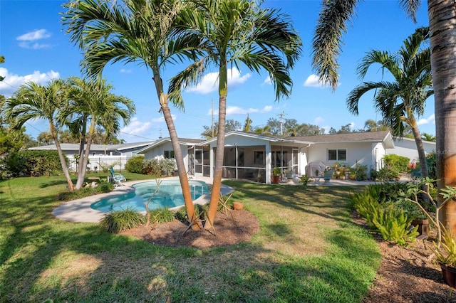 back of property with a lawn and a sunroom