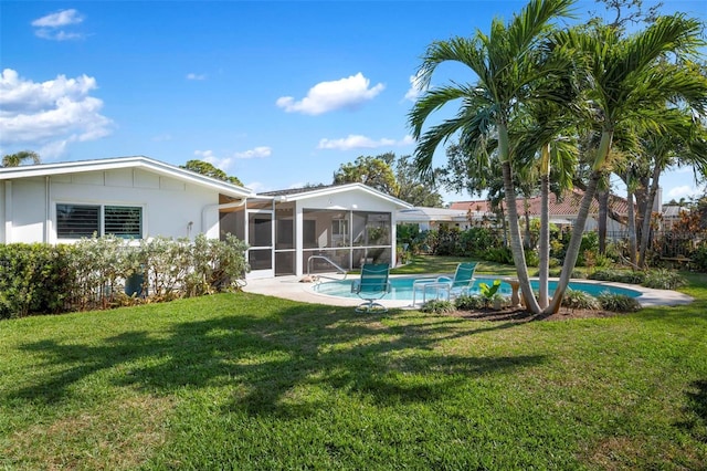 rear view of house with a sunroom, a fenced in pool, and a yard