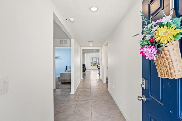 16766 Carlton Pond St, Wimauma, FL 33598 - hallway featuring a textured ceiling and light tile patterned floors