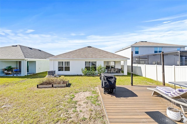 16766 Carlton Pond St, Wimauma, FL 33598 - rear view of house with a wooden deck, cooling unit, and a lawn