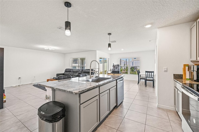 16766 Carlton Pond St, Wimauma, FL 33598 - kitchen featuring light tile patterned floors, gray cabinets, appliances with stainless steel finishes, a kitchen island with sink, and sink