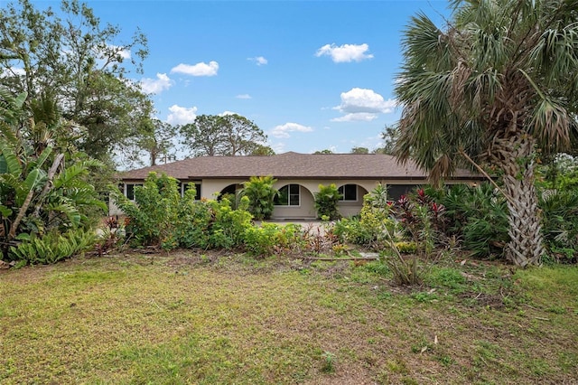 ranch-style home featuring a front lawn