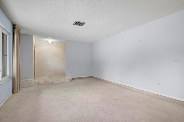 carpeted spare room featuring a textured ceiling