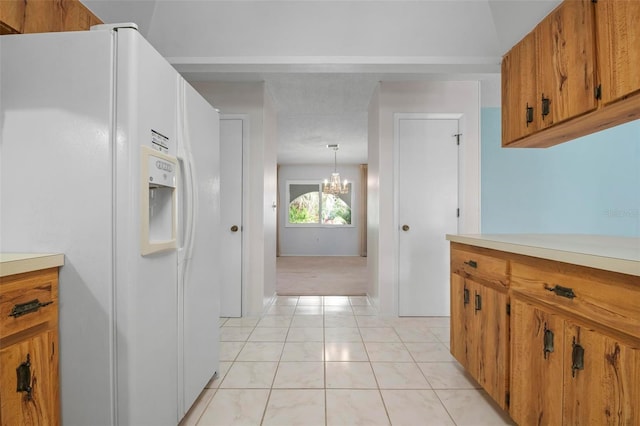 kitchen featuring white refrigerator with ice dispenser, pendant lighting, a chandelier, and light tile patterned floors