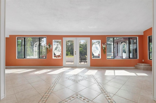 interior space with light tile patterned floors and french doors