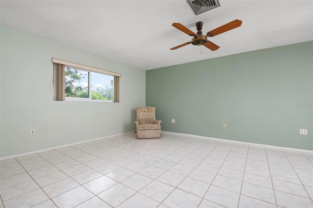 tiled spare room featuring ceiling fan