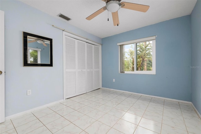 unfurnished bedroom featuring ceiling fan and a closet