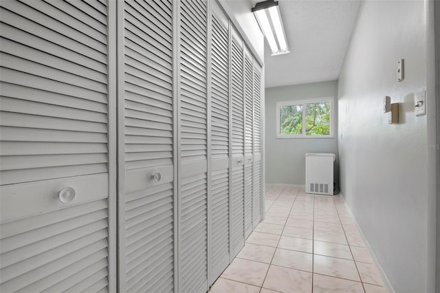 hall featuring light tile patterned floors