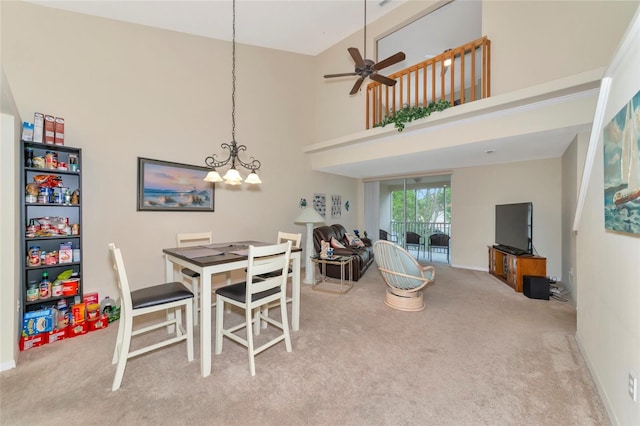 carpeted dining area featuring a high ceiling and ceiling fan