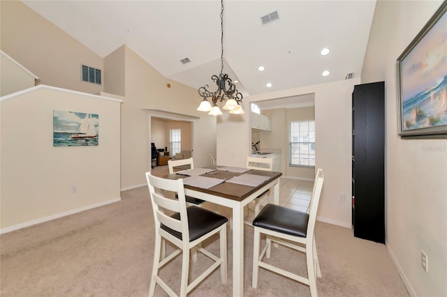 carpeted dining space with vaulted ceiling and an inviting chandelier