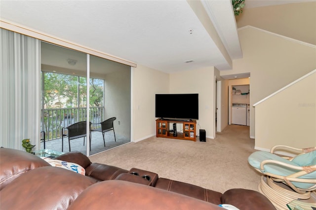 carpeted living room featuring independent washer and dryer