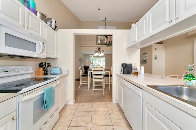 kitchen with white cabinets, decorative light fixtures, light colored carpet, and white appliances