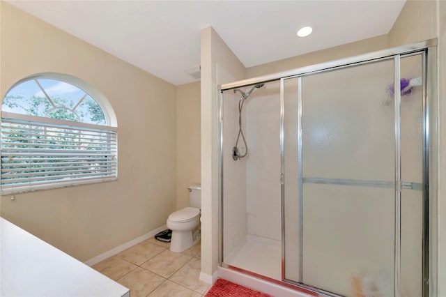 bathroom featuring tile patterned flooring, toilet, and a shower with shower door