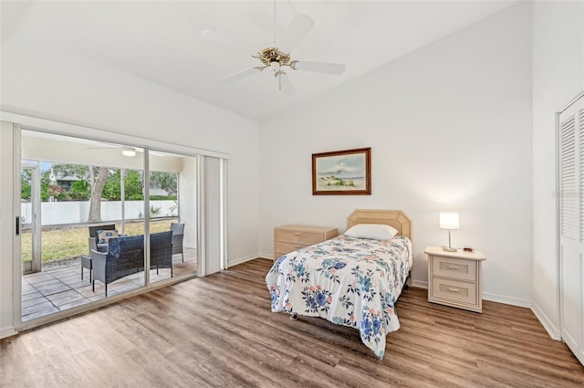 bedroom featuring ceiling fan, access to exterior, vaulted ceiling, hardwood / wood-style flooring, and a closet