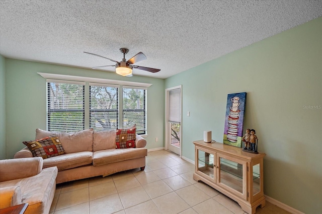 living room featuring ceiling fan, a textured ceiling, and light tile patterned floors