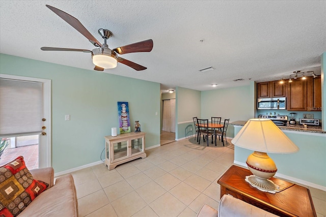 tiled living room with ceiling fan and a textured ceiling