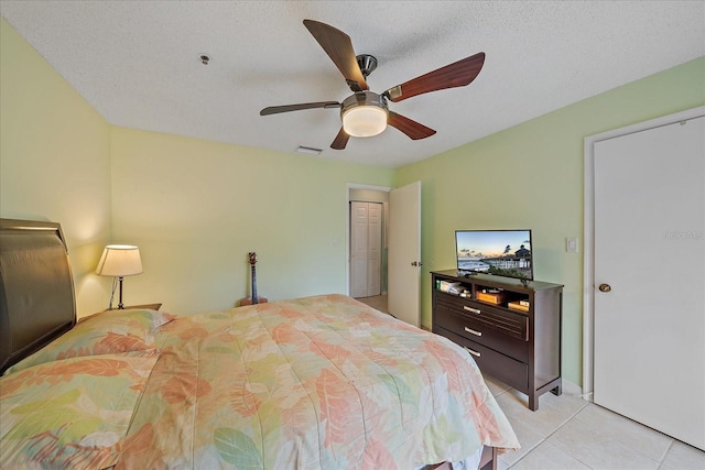 tiled bedroom featuring ceiling fan and a textured ceiling