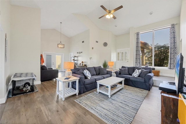 living room featuring ceiling fan, wood-type flooring, high vaulted ceiling, and french doors