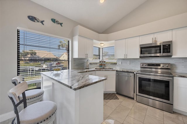 kitchen featuring white cabinetry, sink, stainless steel appliances, kitchen peninsula, and light tile patterned floors