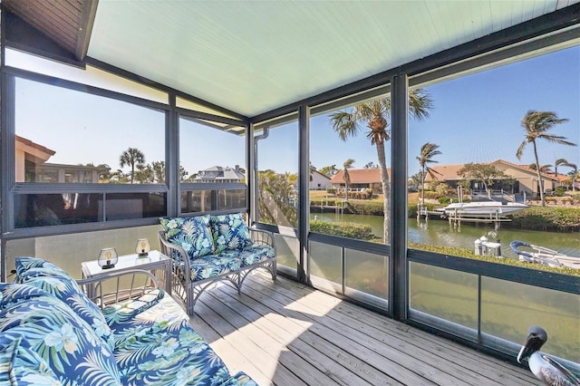 sunroom featuring a water view and vaulted ceiling