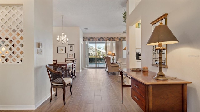 hall with hardwood / wood-style floors and an inviting chandelier