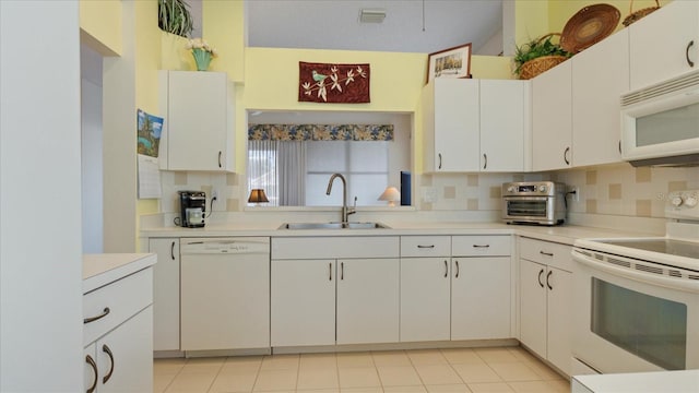 kitchen with sink, light tile patterned floors, backsplash, white appliances, and white cabinets