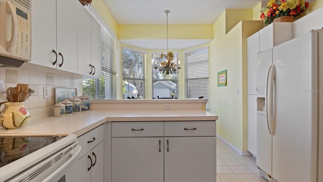 kitchen featuring white cabinetry, backsplash, a chandelier, decorative light fixtures, and white appliances