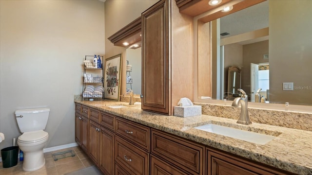 bathroom with tile patterned flooring, vanity, and toilet