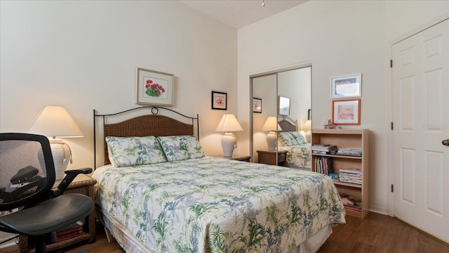 bedroom with dark hardwood / wood-style floors and a closet