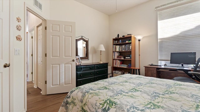 bedroom featuring wood-type flooring and vaulted ceiling