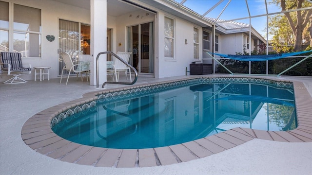 view of pool with glass enclosure and a patio