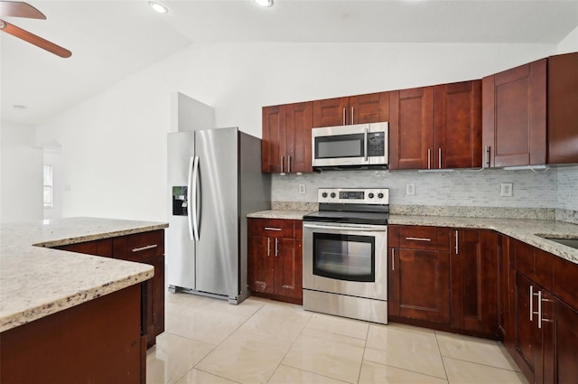 kitchen with light tile patterned floors, appliances with stainless steel finishes, vaulted ceiling, and backsplash