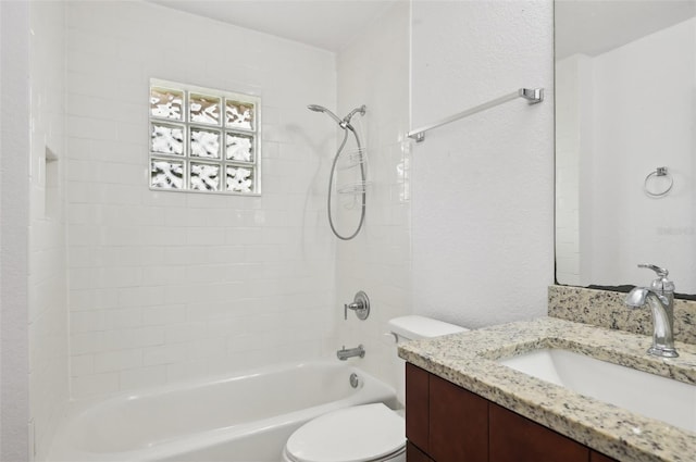 full bathroom with tiled shower / bath, vanity, and toilet